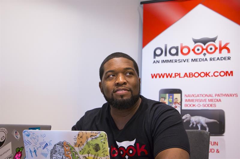 Philip Hickman of Plabook discusses work with a coworker in his office space