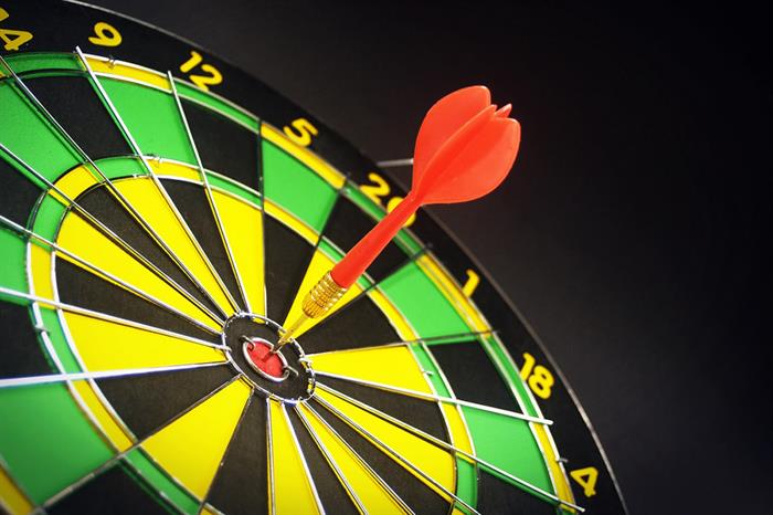 A dart sticks out of the bull's eye on a dartboard