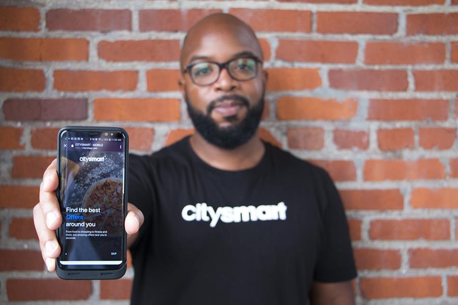 Donald Hawkins, of CitySmart, Griffin Technologies, holds a smartphone that displays his app.