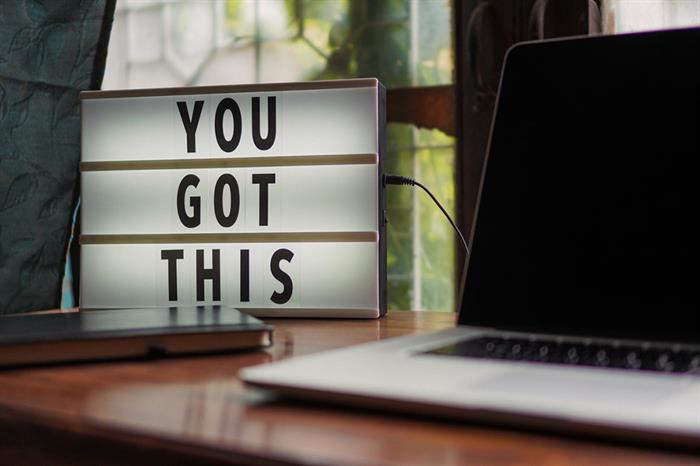 a sign that reads "You Got This" is next to a laptop computer