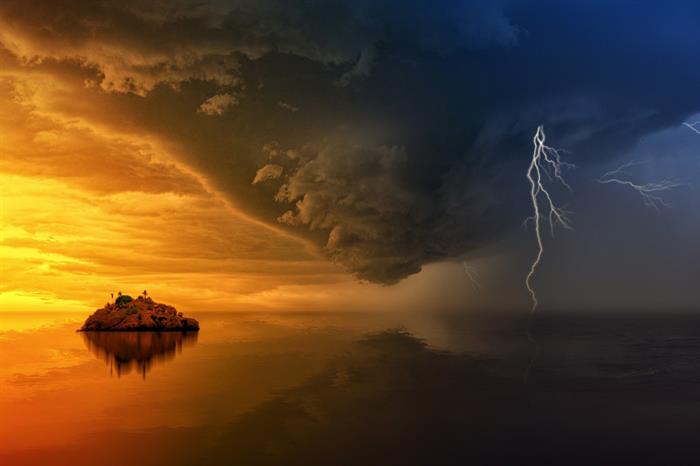 A computer-generated image of an island sunset juxtaposed by a stormy sea
