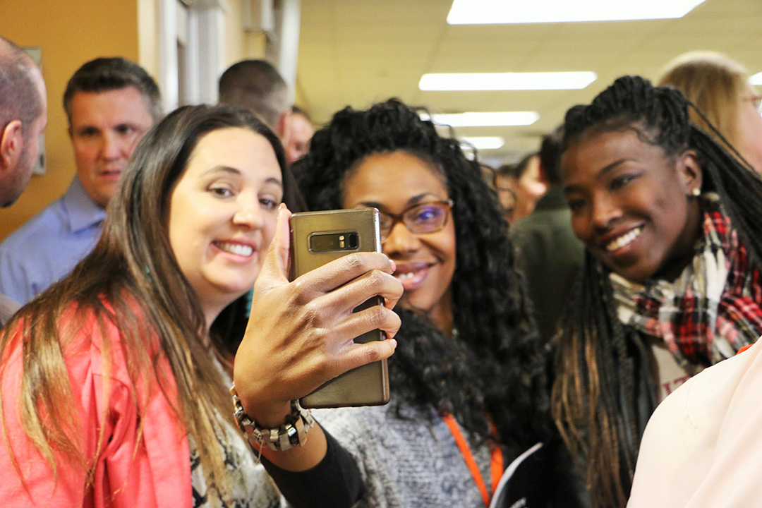 GEWKC attendees pose in front of a smartphone