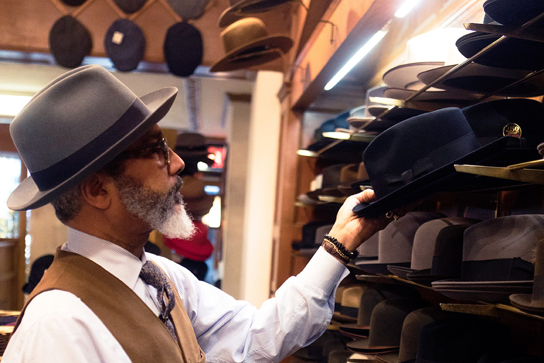 A man peruses the hats at a store