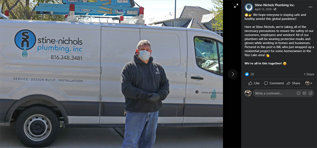 A Stine-Nichols Plumbing employee wears a mask next to a company vehicle after a job