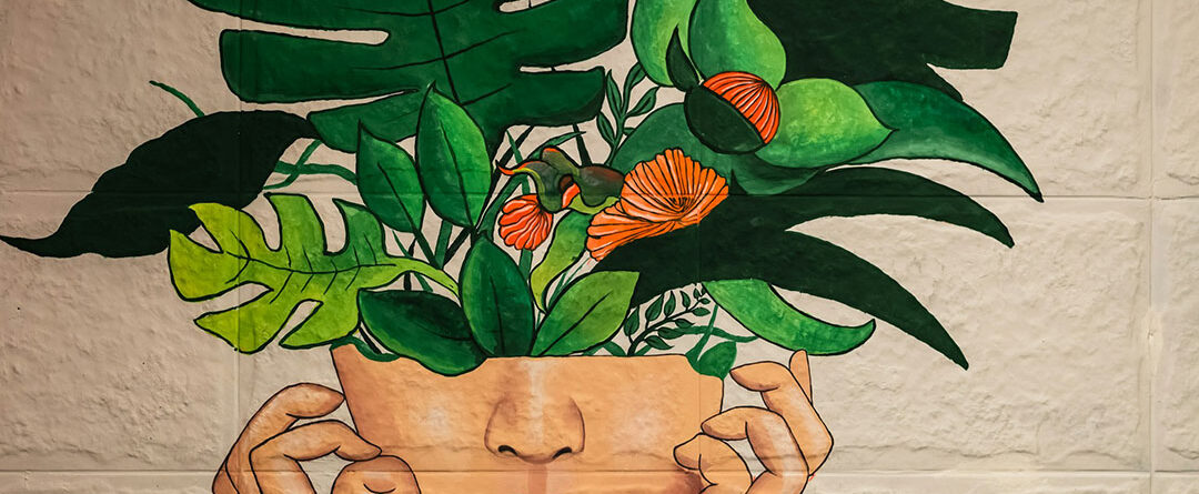 A painting of plants growing out of a woman's head
