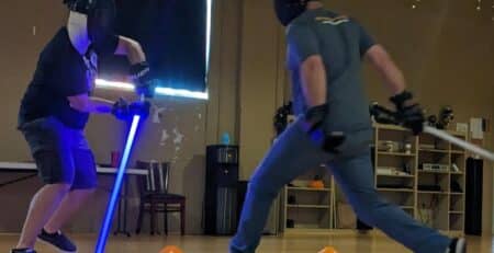 Two lightsaber duelists clash at a Galactic Saber League event